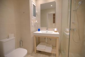 a bathroom with a toilet and a sink and a shower at Elea Beach Hotel in Dassia