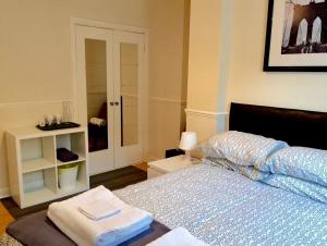 Be My Guest Liverpool - Ground Floor Apartment with Parking في ليفربول: غرفة نوم عليها سرير وفوط