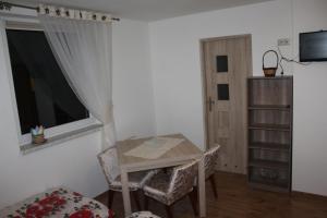 ブレンナにあるDomek "Madzia"のテーブルと椅子、窓が備わる客室です。