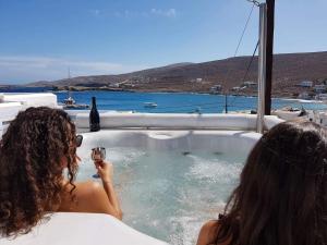 two women in a bath tub with a glass of wine at AMO Folegandros in Karavostasi