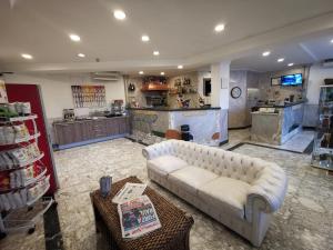 ein Wohnzimmer mit einem weißen Sofa und einer Küche in der Unterkunft Hotel Clinton in Casoria