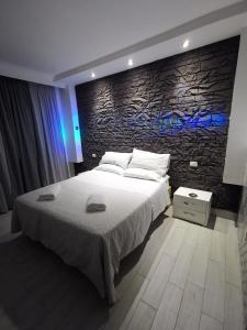 sypialnia z dużym łóżkiem i kamienną ścianą w obiekcie Hotel Clinton w mieście Casoria