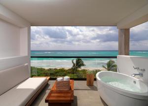 a bathroom with a tub and a view of the ocean at Unico Hotel Riviera Maya Adults Only in Akumal