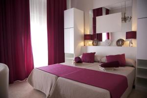 a bedroom with a large bed with purple sheets at Apartamentos Plaza de Austria in Córdoba