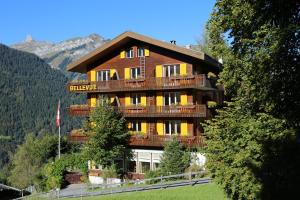 a large wooden building with balconies on a mountain at Hotel Bellevue - Traditional Swiss Hideaway in Wengen +133 photos