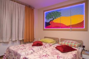 um quarto com uma cama e um quadro na parede em Rooms Vlado em Daruvar