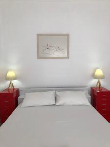 アギア・トリアダにあるTrinity Family Apartmentのベッドルーム1室(白いベッド1台、赤いナイトスタンド2台付)