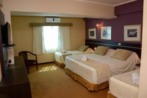 Habitación de hotel con 2 camas y ventana en leclub resort hotel en Encarnación