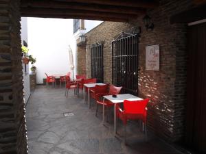 a row of tables and chairs in a brick building at Apartamentos El Mirador in Bérchules