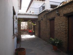 an alley with a brick building and a balcony at Apartamentos El Mirador in Bérchules