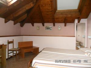 a bedroom with two beds and a table and a desk at Il Campanile Hotel - La Cantina Del Pittore in Miazzina