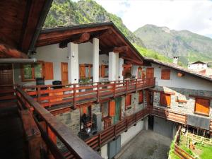 a house with a balcony with mountains in the background at Belvilla by OYO Chalet Antey Penta in Antey-Saint-André