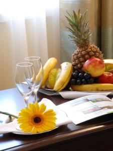 プラハにあるEAホテルダウンタウンのワイングラス2杯付きのテーブルに盛られた果物