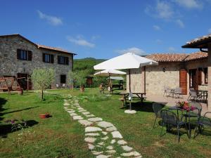 een tuin met een tafel en stoelen en een parasol bij Belvilla by OYO Giulio Cesare in Passignano sul Trasimeno