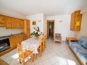 eine Küche und ein Esszimmer mit einem Tisch und einem Sofa in der Unterkunft Chalet village situated in a quiet area in Antey-Saint-André