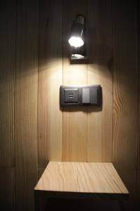 una luce su una parete di legno con panca di Machim House by AnaLodges a Machico