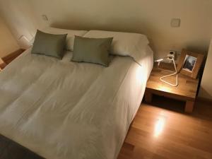 a large white bed with two pillows and a lamp at Atrio Zamora in Zamora