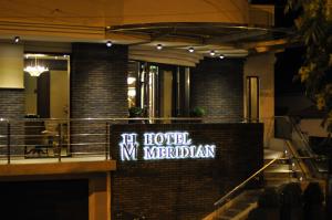 um sinal de hotel no meridiano ao lado de um edifício em Hotel Meridian em Cluj-Napoca