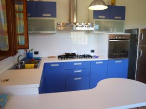 uma cozinha com armários azuis e um frigorífico de aço inoxidável em Belvilla by OYO Valleriana em San Quirico