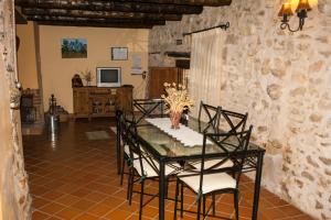 a dining room with a glass table and chairs at Masada Andabe in Las Cuevas de Cañart