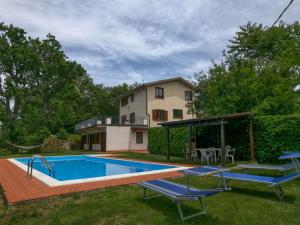 a swimming pool with two chairs and a house at Belvilla by OYO Villa Insieme in San Valentino in Abruzzo Citeriore
