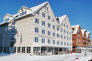 a large white building with snow on top of it at Clarion Collection Hotel With in Tromsø