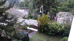 un patio trasero con un jardín con flores y una valla en KANDY Holiday Residence, en Kandy