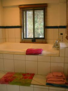 a bathroom with a tub and a window and towels at Casa Volcano Panoramic View in Vara Blanca