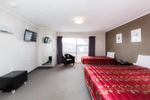 una camera d'albergo con due letti e una sedia di Manfeild Park Motel a Feilding