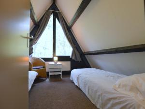 a bedroom with a canopy bed and a window at Holiday home Eekhoorn in Stramproy
