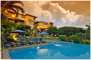 a resort with a swimming pool with chairs and umbrellas at Amarela Resort in Panglao Island