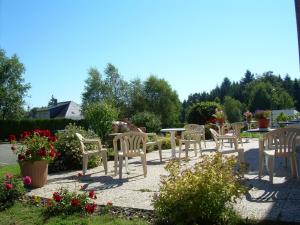 Hotel Le Chavanon في Merlines: مجموعة من الكراسي وطاولة مع الزهور