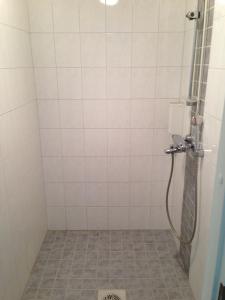 a bathroom with a shower with a tile floor at Huoneistohotelli Lumihovi in Jämijärvi