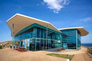 a large glass building with benches in front of the ocean at BIG4 Ingenia Holidays Phillip Island in Newhaven