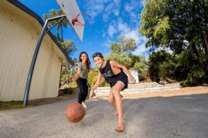 mężczyzna i kobieta grający w koszykówkę z obręczą w obiekcie BIG4 Ingenia Holidays Phillip Island w mieście Newhaven