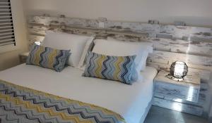 a bed with white pillows at Beach House in Plakias
