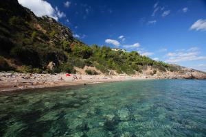 a beach with a bunch of people in the water at Sea House Porto Ercole in Porto Ercole