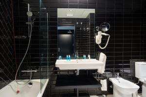 a bathroom with a sink, mirror, and bathtub at Costa del Sol Torremolinos Hotel in Torremolinos