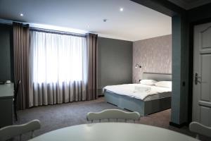 a bedroom with a bed and a large window at Olympica Hotel in Almaty +49 photos
