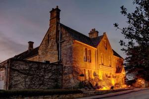 an old stone building with lights on it at night at Three Ways House Hotel in Chipping Campden