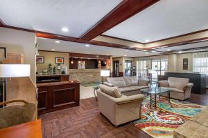 uma sala de estar com um sofá e uma mesa em Quality Suites Addison-Dallas em Addison