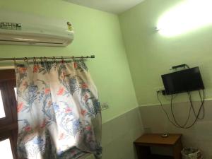 een kamer met een bed met een gordijn en een televisie bij Hotel Deep Mandir in Jaipur