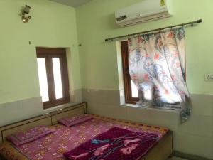 a room with a bed and a mirror and a window at Hotel Deep Mandir in Jaipur