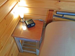 uma mesa com um despertador ao lado de uma cama em Picton Campervan Park em Picton