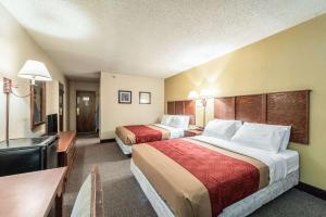 a hotel room with two beds and two lamps at Econo Lodge in Brainerd