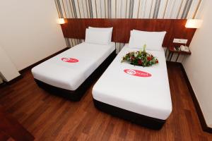 2 Betten in einem Hotelzimmer mit Blumen darauf in der Unterkunft My Hotel @ KL Sentral in Kuala Lumpur