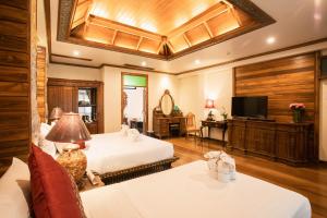 a hotel room with a large bed and a large window at Pingviman Hotel in Chiang Mai