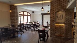 ein Restaurant mit Tischen und Stühlen und einer Backsteinmauer in der Unterkunft Turmklause in Luckenwalde