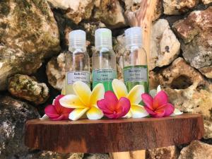 three bottles of essential oils and flowers on a shelf at The Ulus Klumpu in Uluwatu