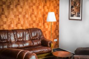 a brown leather couch in a living room with a lamp at VILLA CENTRUM APARTMÁNY s RAŇAJKAMI A SAUNOU in Martin